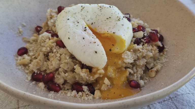 savory oatmeal with poached egg, pomegranate seeds, parmesan cheese