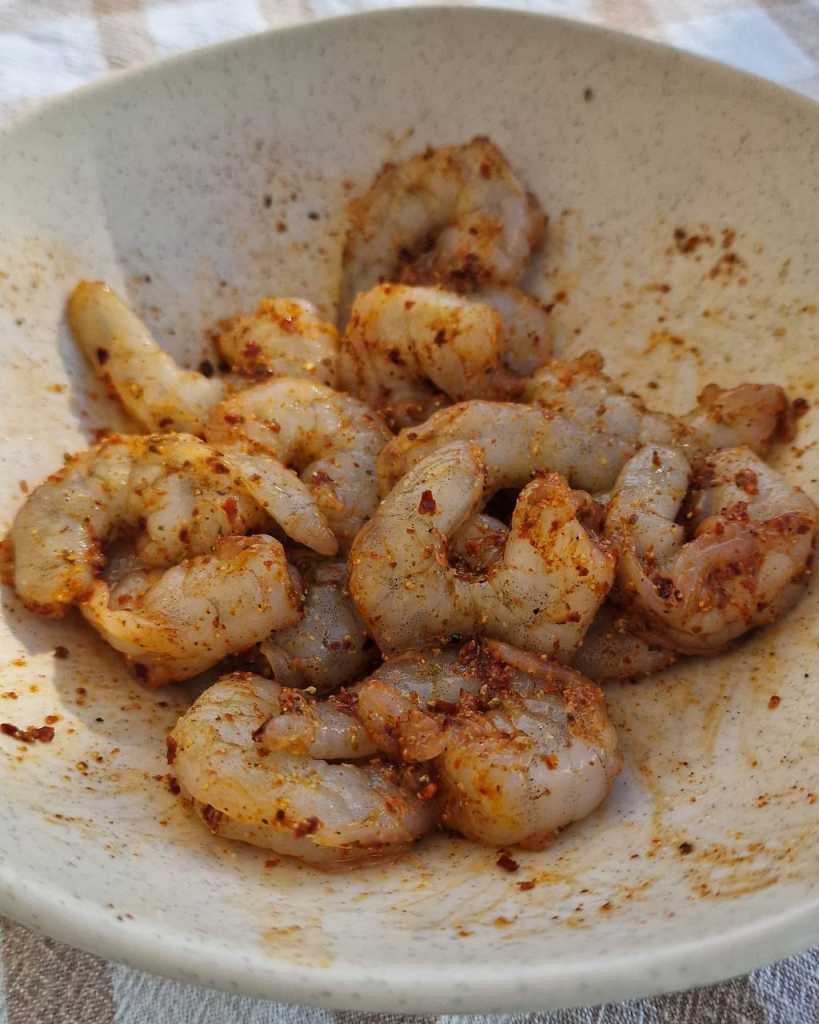 shrimp covered in fajita spices for Sheet Pan Shrimp Fajitas recipe 