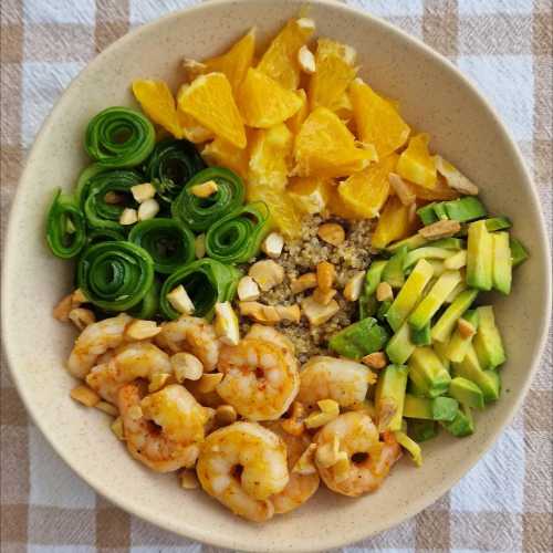 Quinoa bowl with shrimp, oranges, avocado, and cucumbers